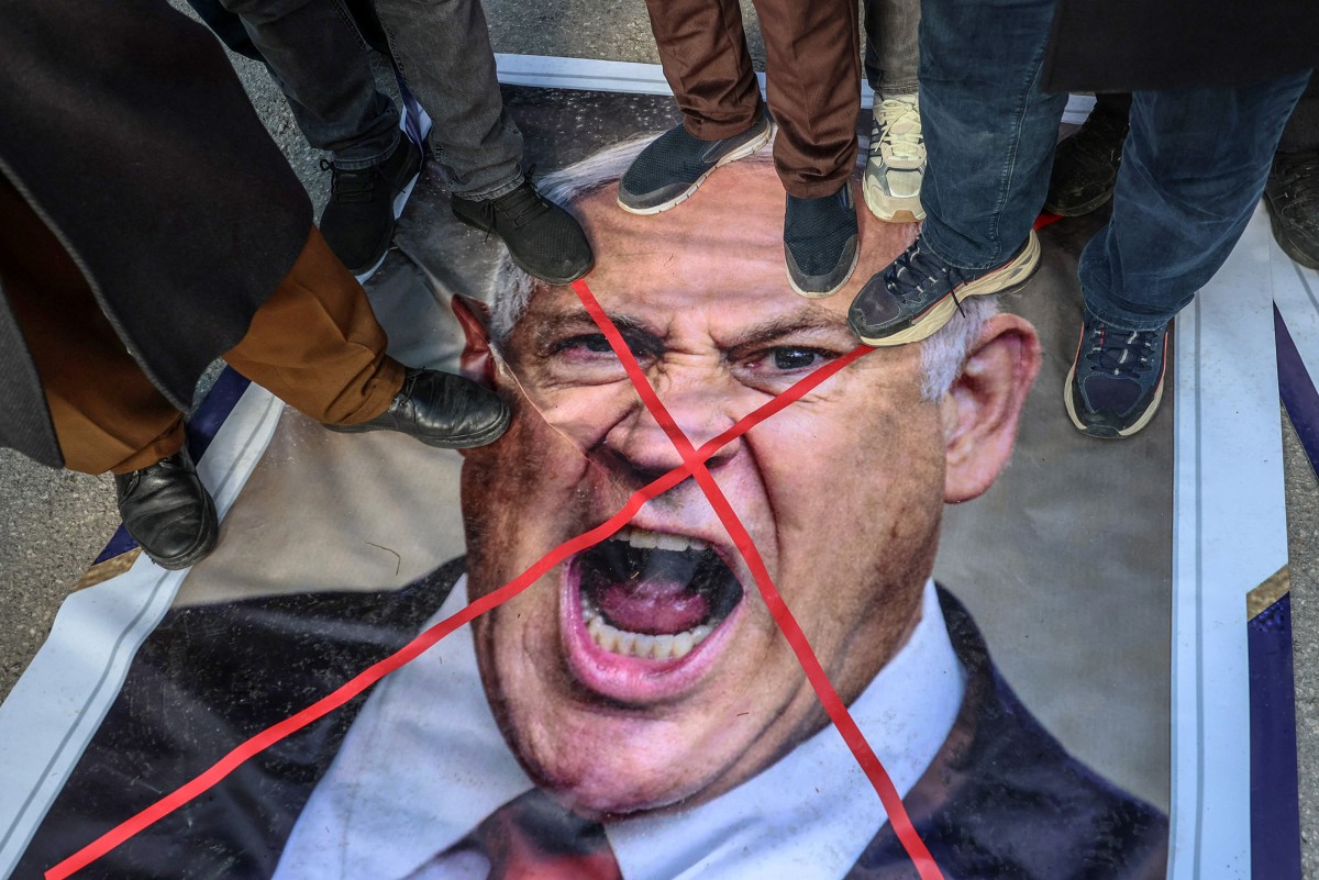 আঙ্কারায় ইসরায়েলি প্রধানমন্ত্রী বেনিয়ামিন নেতানিয়াহুর ছবির ওপর দাঁড়িয়ে ইরানের বিরুদ্ধে ইসরায়েল-যুক্তরাষ্ট্রের হামলার প্রতিবাদ জানাচ্ছেন বিক্ষোভকারীরা। ছবি: এএফপি 