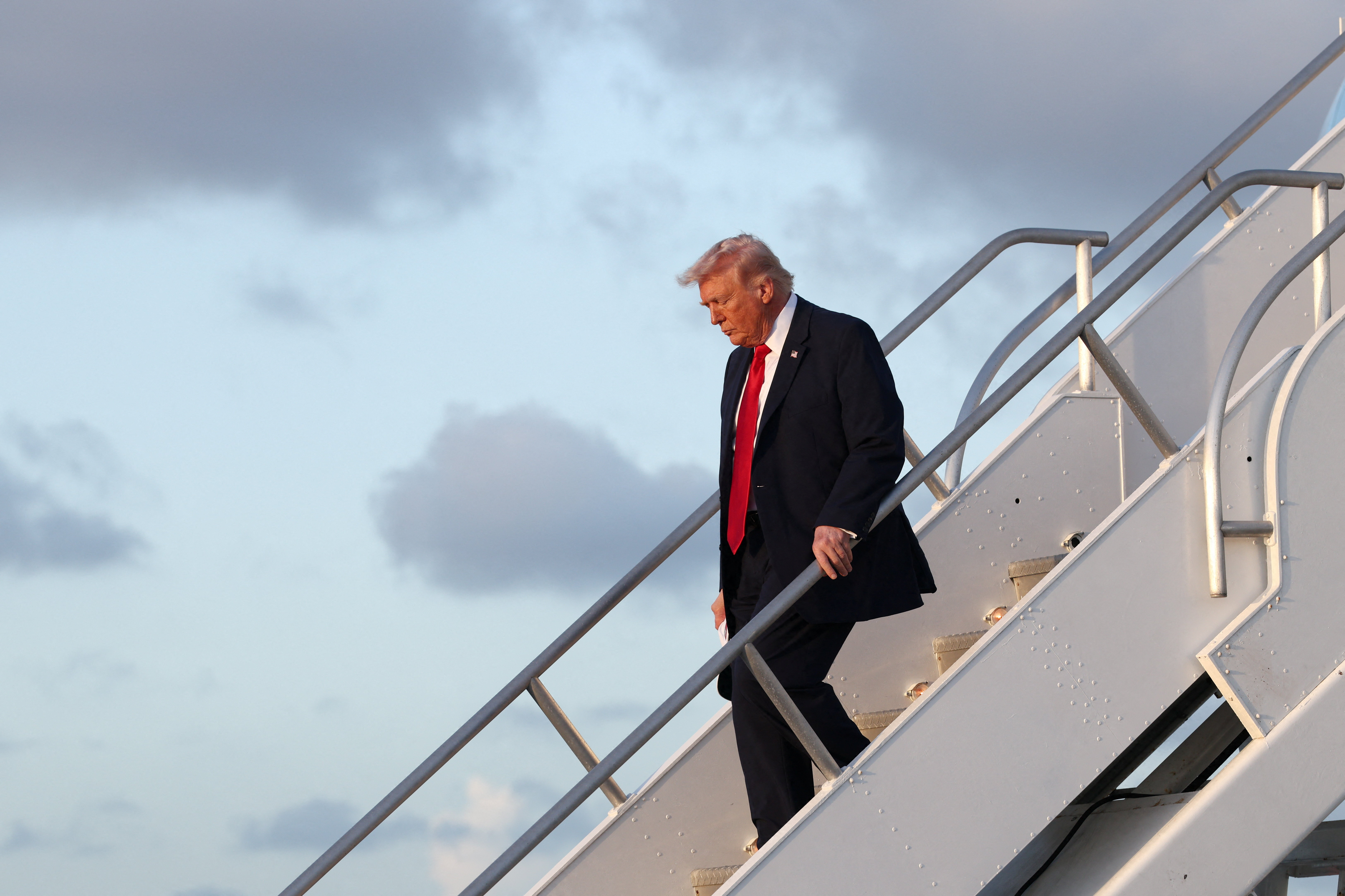 মায়ামিতে এয়ারফোর্স ওয়ান থেকে নেমে আসছেন ডোনাল্ড ট্রাম্প। ছবি: রয়টার্স