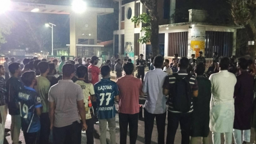 চট্টগ্রাম বিশ্ববিদ্যালয়ের শিক্ষার্থীদের ওপর স্থানীয়দের হামলার প্রতিবাদে ক্যাম্পাসের ফটকে শুক্রবার রাতে শিক্ষার্থীদের বিক্ষোভ। ছবি: স্টার