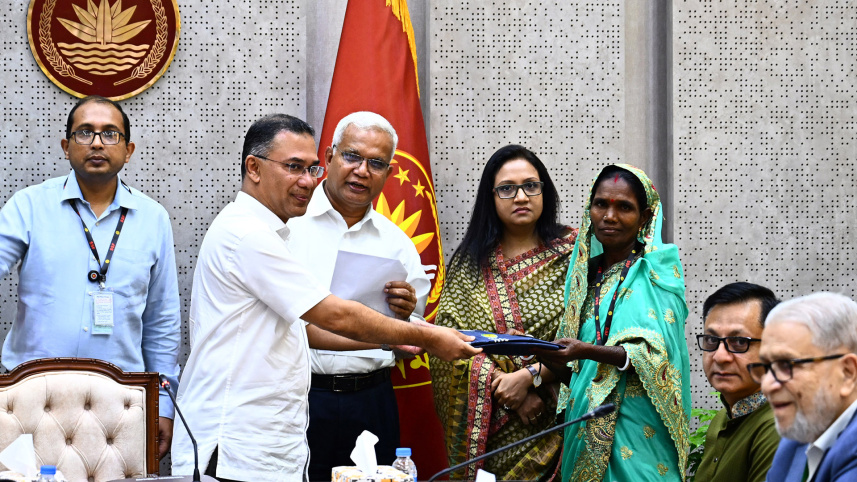 রেইনকোট বিতরণ করছেন প্রধানমন্ত্রী তারেক রহমান। ছবি: পিআইডি