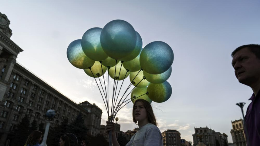 স্বাধীনতা দিবস উপলক্ষে ইউক্রেনের পতাকার রঙে রাঙানো বেলুন বিক্রি করছেন এক ব্যক্তি। ছবি: এপি