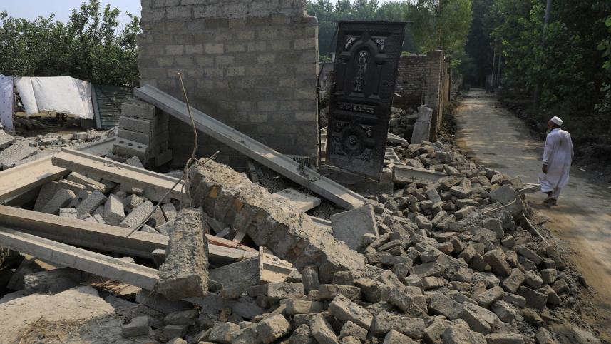 পাকিস্তানের চারসাদ্দা জেলায় বন্যায় ভেঙে পড়া নিজের বাড়ি দেখছেন এক প্রৌঢ়। ছবি: রয়টার্স