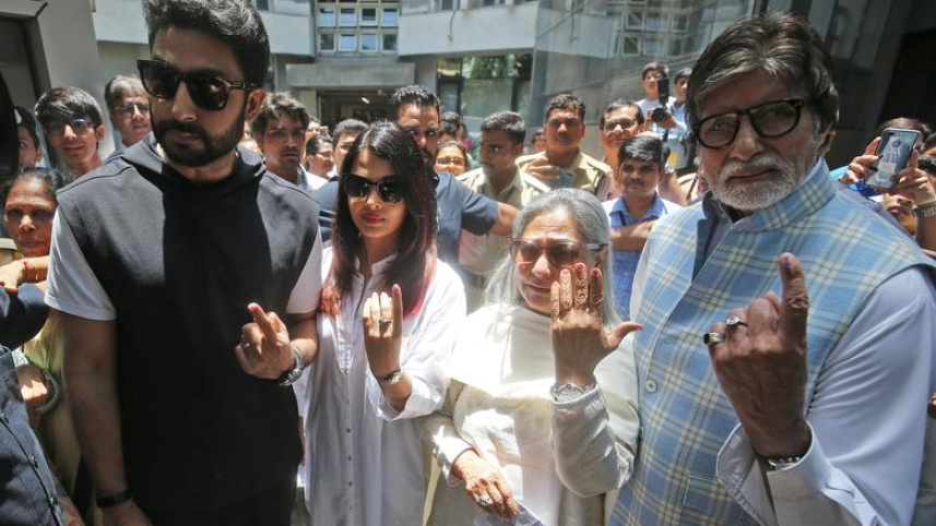 পরিবারের সদস্যদের সঙ্গে ভোটকেন্দ্র থেকে বের হয়ে আসছেন অমিতাভ। ছবি: রয়টার্স