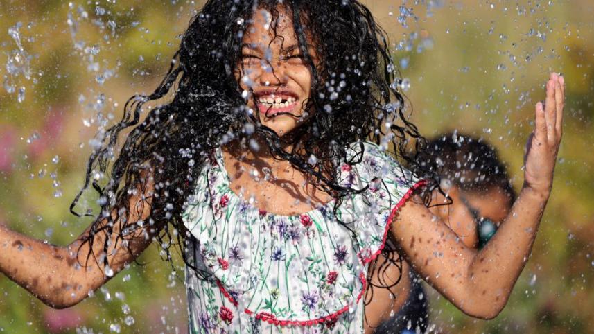 ৭ বছর বয়সী মার্কিন শিশু আইসিস তাপদাহের হাত থেকে বাঁচতে পানি নিয়ে খেলছে। ফাইল ছবি: রয়টার্স