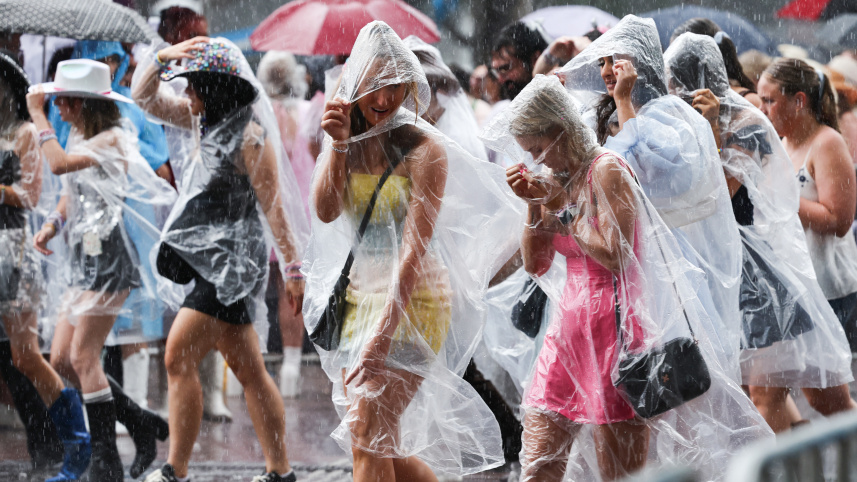 বৃষ্টি উপেক্ষা করে টেইলর সুইফটের গান শুনতে যাচ্ছেন 'সুইফটি'রা। ছবি: এএফপি