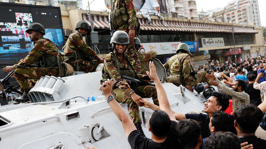 শেখ হাসিনার পদত্যাগের পর জনসাধারণের সঙ্গে উৎসবে শামিল হন সেনাবাহিনীর সদস্যরা। ছবি: রয়টার্স