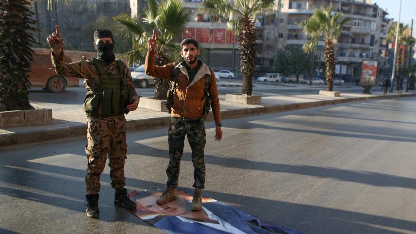 আলেপ্পো দখলে নিয়ে আসাদের মুখাবয়ব সম্বলিত ছবির ওপর দাঁড়িয়ে আছেন বিদ্রোহীরা। ছবি: এএফপি