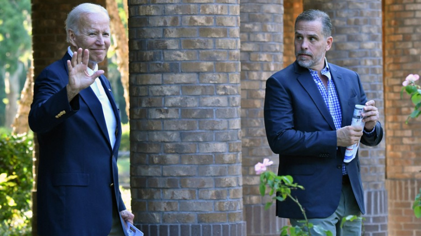 চার্চ থেকে বের হয়ে এসে ভক্তদের অভিবাদনের জবাব দিচ্ছেন জো বাইডেন। পাশে সন্তান হান্টার। ফাইল ছবি: এএফপি