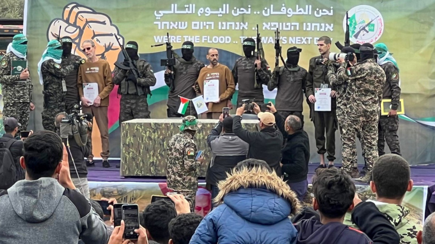 হামাসের আল-কাসাম ব্রিগেডের যোদ্ধারা জিম্মিদের ঘিরে রাখে। ছবি: এএফপি