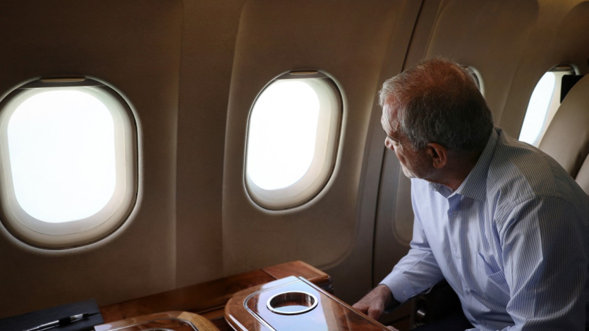 উড়োজাহাজের জানালা দিয়ে বাইরে তাকিয়ে বিস্ফোরণের ক্ষয়ক্ষতি বোঝার চেষ্টা করছেন ইরানের প্রেসিডেন্ট। ছবি: এএফপি