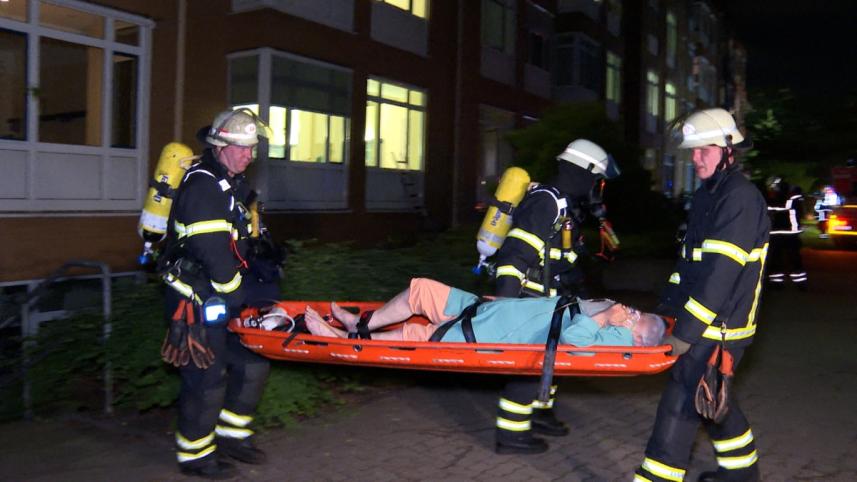 হামবুর্গের মারিয়েনক্র্যানকেনহস হাসপাতালে অগ্নিকাণ্ডে আহত এক ব্যক্তিকে উদ্ধার করে নিয়ে এসেছেন দমকল বাহিনীর কর্মকর্তারা। ছবি: এএফপি