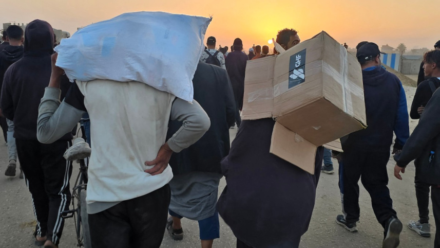 জিএইচএফের ত্রাণকেন্দ্র থেকে ত্রাণ না পেয়ে খালি বাক্স কাঁধে বাড়ি ফিরছেন এক ফিলিস্তিনি । ছবি: এএফপি