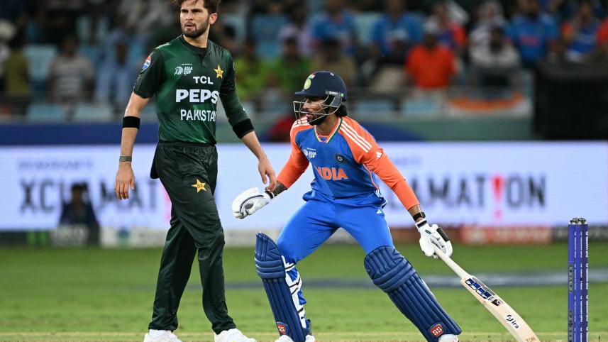 India's Tilak Varma (R) runs between the wickets as Pakistan's Shaheen Shah Afridi watches 