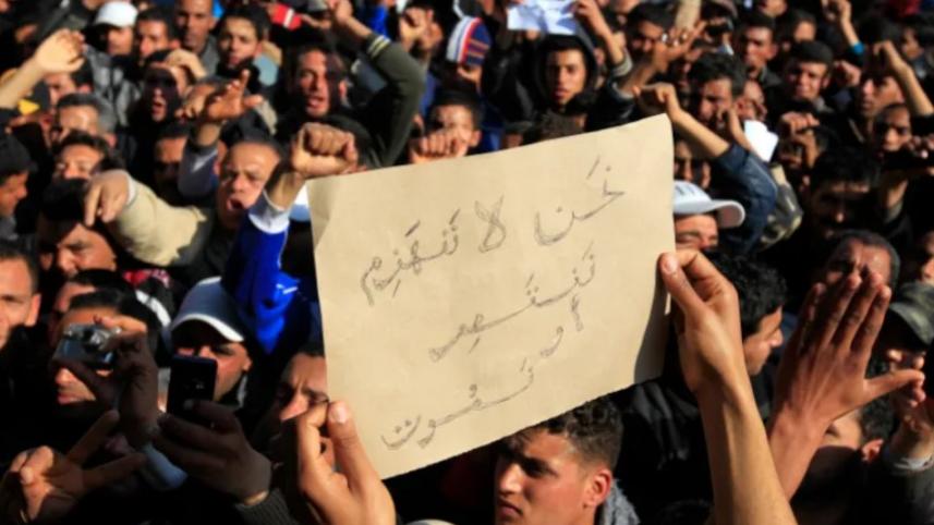 সিদি বোজিদে ক্ষমতাসীন দলের বিরুদ্ধে বিক্ষোভ করছে তিউনিসিয়ার জনগণ। প্ল্যাকার্ডে লেখা, ‘আমরা পরাজিত হব না। বিজয় অথবা মৃত্যু’। ফাইল ছবি” জোহরা বেনসেমরা/রয়টার্স (জানুয়ারি ২০১১) 