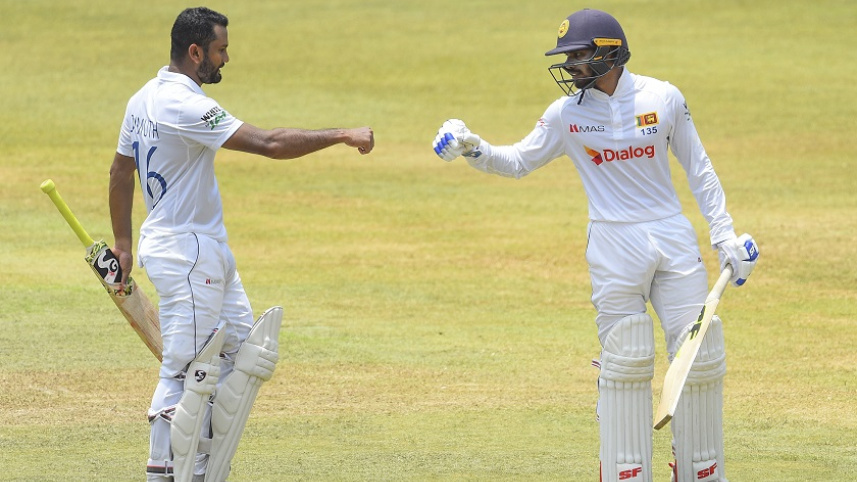 Dimuth Karunaratne and Dhananjaya de Silva  bump fists during their 3rd wicket partnership.jpg