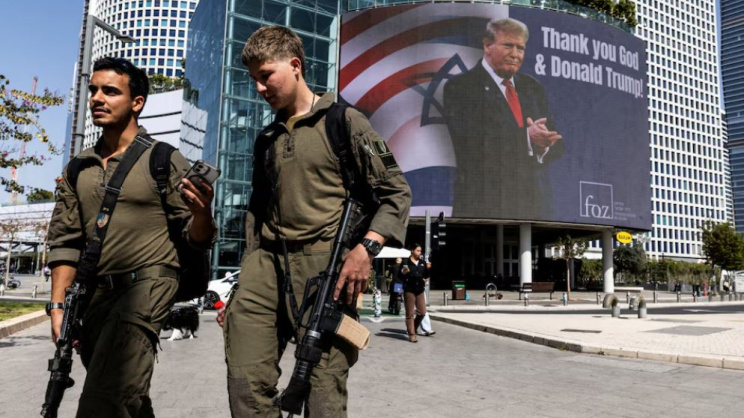 ইসরায়েলের তেল আবিবে এক বিলবোর্ডে ট্রাম্পের ছবির পেছনে যুক্তরাষ্ট্র ও ইসরায়েলের পতাকা। আর এক পাশে লেখা—‘ঈশ্বর ও ডোনাল্ড ট্রাম্পকে ধন্যবাদ’। ছবি: রয়টার্স