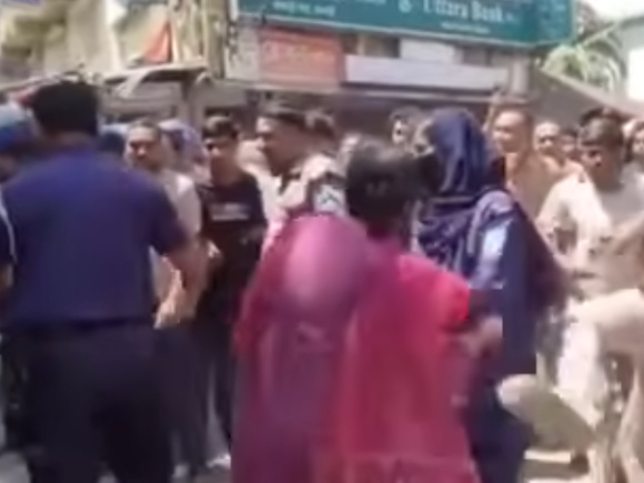 পুলিশের সামনে ওই নারীকে লাথি মারছেন এক যুবক। ছবি: ভিডিও থেকে নেওয়া