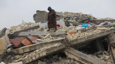 সিরিয়ার জানদারিস শহরে ধ্বংসস্তুপের ওপর এক ব্যক্তি দাঁড়িয়ে আছেন। ছবি: রয়টার্স