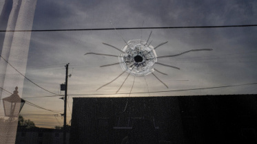 ম্যাহোগনি মাস্টারপিস ড্যান্স স্টুডিওর প্রবেশপথে বুলেটের আঘাতে কাঁচ ক্ষতিগ্রস্থ হয়। ছবি: রয়টার্স