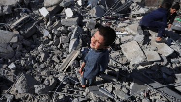 দক্ষিণ গাজার রাফাহ শহরের এক বাড়িতে ইসরায়েলি বিমানহামলার পর ঘটনাস্থলে কৌতুহলী শিশুদের পদচারণা। ছবি: রয়টার্স (ডিসেম্বর , ২০২৩)