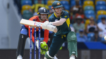 Australia's David Warner (R) hits as England's captain Jos Buttler (L) 