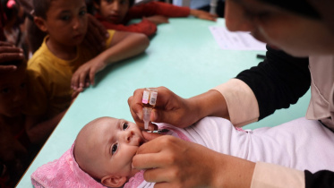 এক ফিলিস্তিনি শিশুকে টিকা দিচ্ছেন স্বাস্থ্যকর্মী। ছবি: এএফপি