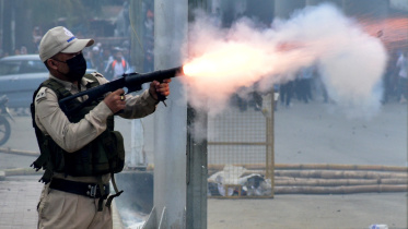 মণিপুরে শিক্ষার্থীদের ছত্রভঙ্গ করতে টিয়ার গ্যাস শেল ছুঁড়ছেন পুলিশ কর্মকর্তা। ছবি: রয়টার্স