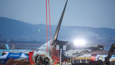 ক্রেন দিয়ে উড়োজাহাজ থেকে ধ্বংস্তুপ পরিষ্কারের চেষ্টা চালানো হচ্ছে। ছবি: রয়টার্স