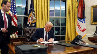 নির্বাহী আদেশে সাক্ষর করছেন ট্রাম্প। ছবি: এএফপি