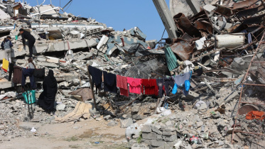 যুদ্ধবিরতি চলাকালীন উত্তর গাজার জাবালিয়ায় ধ্বংস হয়ে যাওয়া বাড়ির সামনে কাপড় শুকাচ্ছেন এক ফিলিস্তিনি নারী। ছবি: এএফপি 