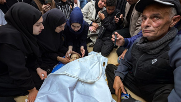 গাজায় ইসরায়েলি হামলায় নিহত ফিলিস্তিনি শিশুকে চিরবিদায় জানাচ্ছে তার আত্মীয় পরিজন। ছবি: এএফপি